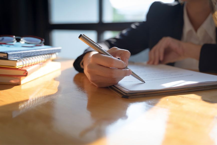 An attorney writing on a paper with a client