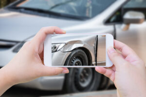 woman using mobile smartphone take photo car crash accident of the damage to the car for accident insurance